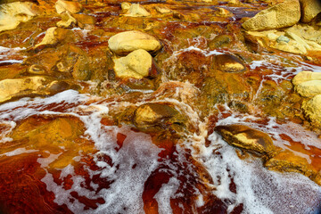 Foamy Waters Flowing Over Rio Tinto's Mineral-Rich Rocks