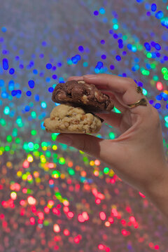Hand holding two cookies with glitter background