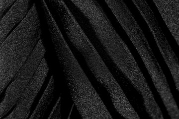 Fototapeta premium Luxury folded black silk fabric texture background close-up overlay macro elegant