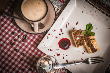 Cheesecake slice, New York style classical cheese cake on wooden background. Slice of tasty cake on white plate served with dessert fork
