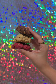 Hand holding chocolate, walnut and red velvet cookies