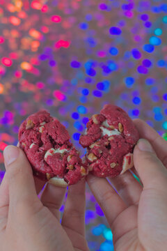 Woman's hands holding red velvet chocolate chip cookie