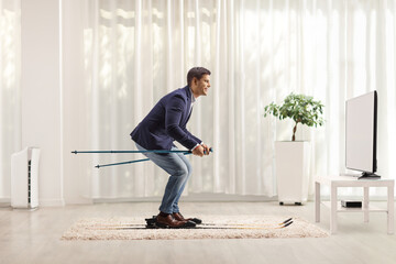 Full length profile shot of a businessman skiing on a carpet in front of tv