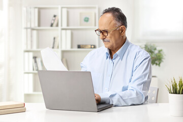 Mature man sitting in an office and working on a laptop