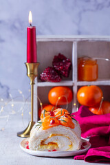 Meringue roll filled with mascarpone, cream and tangerine jam, decorated with tangerines and pomegranate seeds. - 729504334