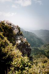 Fototapeta na wymiar Am Felsvorsprung am Berg mit Blick ins bewaldete Tal