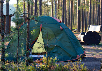 Tent in a tourist camp outdoors. A colorful tent stands in a green forest. Travel Tourism Tourism Leisure Active lifestyle.