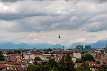Obraz premium Aerial panoramic view of historic city of Udine, Friuli Venezia Giulia, Italy, Europe. Viewing platform form castle of Udine. Cloudy overcast day. Distant view of mountains of Alps, border to Austria