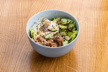 Bowl with tuna on a wooden table