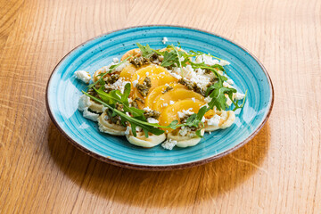 Waffles with Feta, pesto and peach on a blue plate