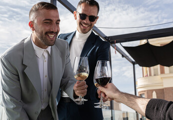 Newly married gay couple toasting with their friends