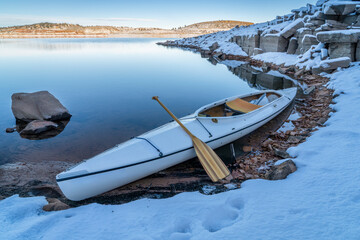 decked expedtion canoe on a shore of Carter Lake in northern Colorado in winter scenery
