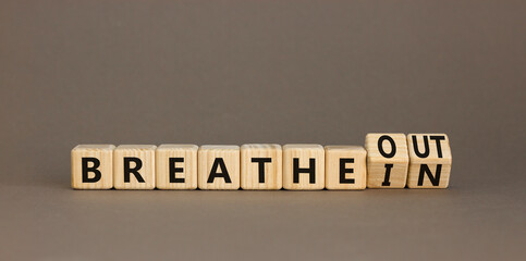 Breathe in and out symbol. Concept words Breathe in to Breathe out on beautiful wooden cubes....