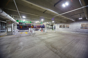 Modern Parking Garage Exit with Yellow Arrows and Illuminated Signs, Wide-Angle