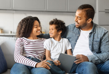 Happy African American Family With Digital Tablet Relaxing Together At Home