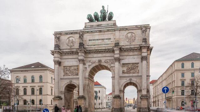 The Siegestor or Victory Gate in Munich is a memorial arch, crowned with a statue of Bavaria with a lion quadriga timelapse. Traffic on the street around the monument. Front view. Germany