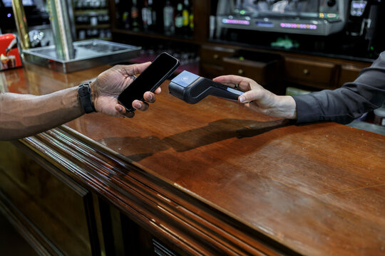 Man paying with his phone in a bar