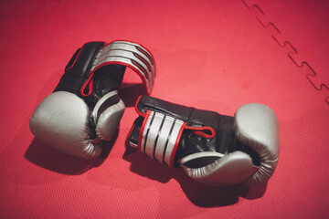 Muay Thai gloves rest on the tatami after an intense training, showcasing determination and passion...
