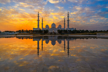 The Sheikh Zayed Grand Mosque, the largest mosque in the UAE at sunset, and reflected in the Oasis of Dignity pond, in Abu Dhabi, United Arab Emirates.