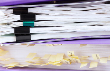 Stack of reporting paper documents in a purple folder with bookmarks, business documents for annual reports. Business analytics. Business office concept, soft focus.