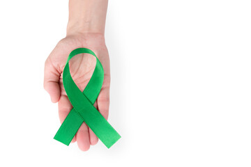 Green satin ribbon on the palm of a woman, isolated on a white background. Cancer awareness symbol. copy space.