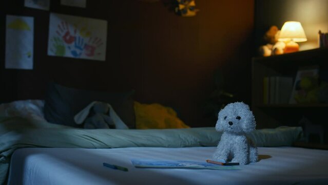 No people handheld footage of empty decorated kids bedroom with white plushie puppy on bed near painting at night