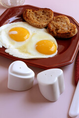 Valentine breakfast: eggs, sunny side up, with heart shaped, toasted English muffins