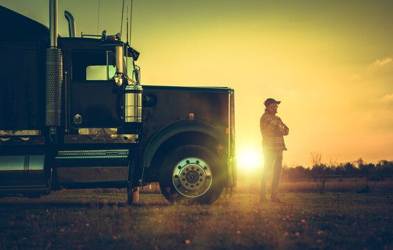 Semi Truck Driver in Front of His Vehicle During Scenic Sunset