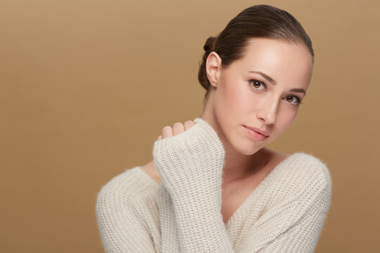 Winter, beauty or portrait of natural model in studio isolated on brown background for fashion or wellness. Face, skincare or space with confident woman or happy person in wool jersey or sweater