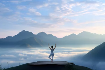 Schilderijen op glas Woman standing on a yoga on a mountain peak in the morning, wallpaper background © Radmila Merkulova