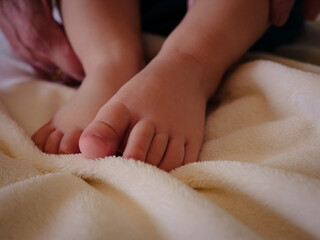 Close-up of tiny, cute, bare toes, heels and feet of a newborn girl, boy. Baby foot on blue soft coverlet, blanket. Detail of a newborn baby legs.Macro horizontal professional studio photo. High