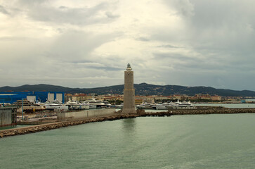 Panoramic landscape view port of Livorno, Italy. Moored luxury yachts and ships. Breakwater and ancient lighthouse in the harbor. Travel and tourism concept