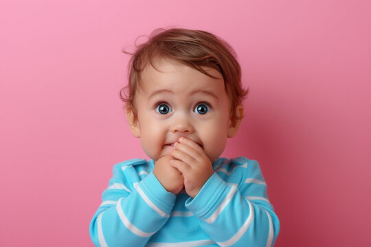 Nervous baby boy and biting nails in studio with oops reaction to gossip on pink background