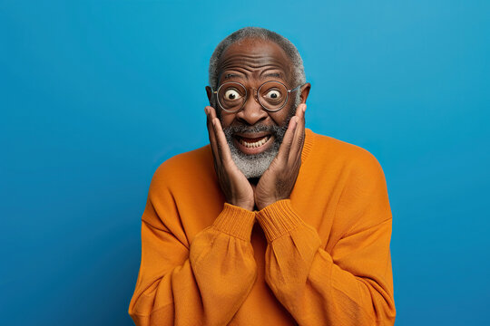 Nervous senior African American man in studio with oops reaction on blue background. Mistake, sorry, drama or secret with regret, shame or awkward