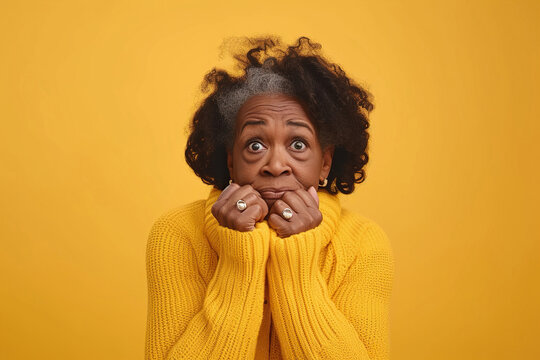 Nervous senior African American woman in studio with oops reaction on yellow background. Mistake, sorry, drama or secret with regret, shame or awkward