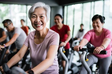Foto op Plexiglas Active Asia senior old woman people training exercise on stationary bike for fit healthy at home gym. © Danko