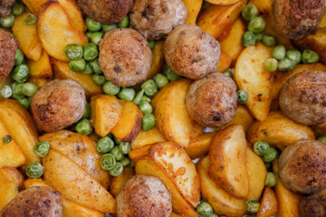 Delicious hot lunch from the oven potato slices, meatballs and green peas