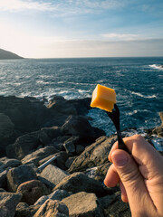 Culinary Contrast: A Cube of Cheese Against the Vast Sea