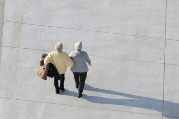 Aerial view of two elderly women walking on a sunny day. Copy space