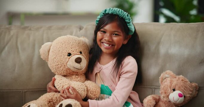 Smile, happy and indian girl with teddy bear on sofa in living room of home, alone for comfort or joy. Portrait, kids and adorable young child in apartment hugging stuffed toy animal for consoling