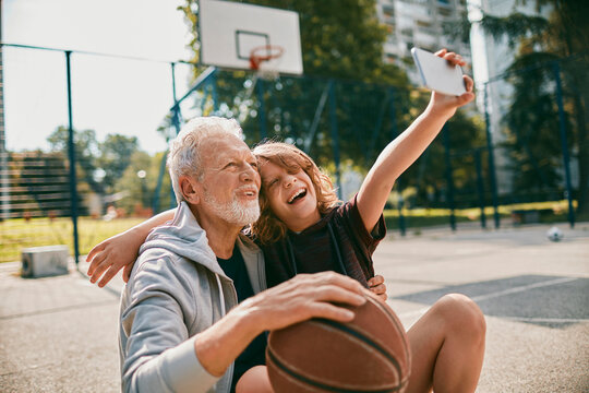 Grandfather and grandson bonding over basketball in a park