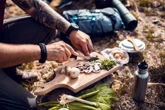 Man preparing food outdoors while camping in nature