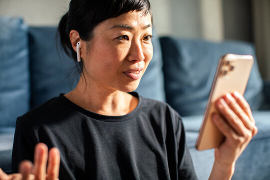 Close up Asian woman holding smartphone at home