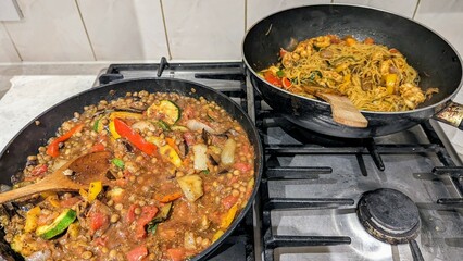 Two home cooked dishes cooking on a stove