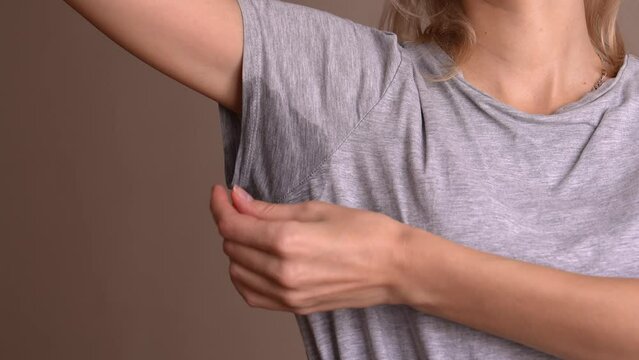 Woman with problem of sweat under her armpits. Concept smells bad. Hyperhidrosis. sweating and agitation. Close-up of spot with hyperhidrosis of sweating under armpit. Concept of health care.