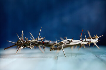 Christian crown of thorns like Jesus Christ wore with blood drops over a rustic wood background or table. Selective focus with blurred background.