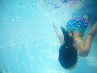 menina fazendo mergulho em piscina 