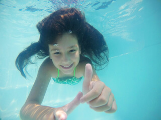 menina fazendo mergulho em piscina 