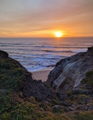 Fototapeta na wymiar glow of sunset colors painting the rugged cliffs and the endless horizon of the Pacific Ocean 