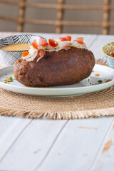 Corviche de verde relleno de pescado en su interior con ensalada de tomate y cebolla y salsas, bocado típico ecuatoriano